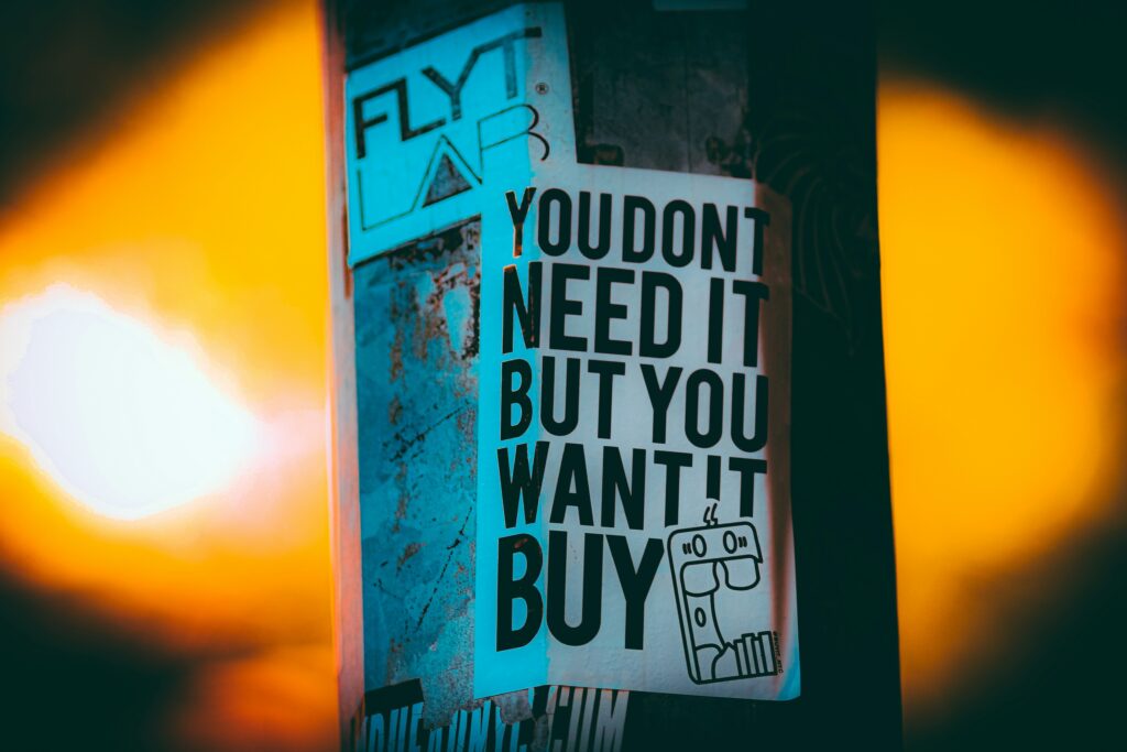 une affiche avec écrit : you don't need it but you want it buy"