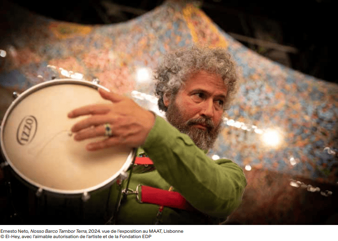 Ernesto Neto dans son oeuvre portant un tambour
