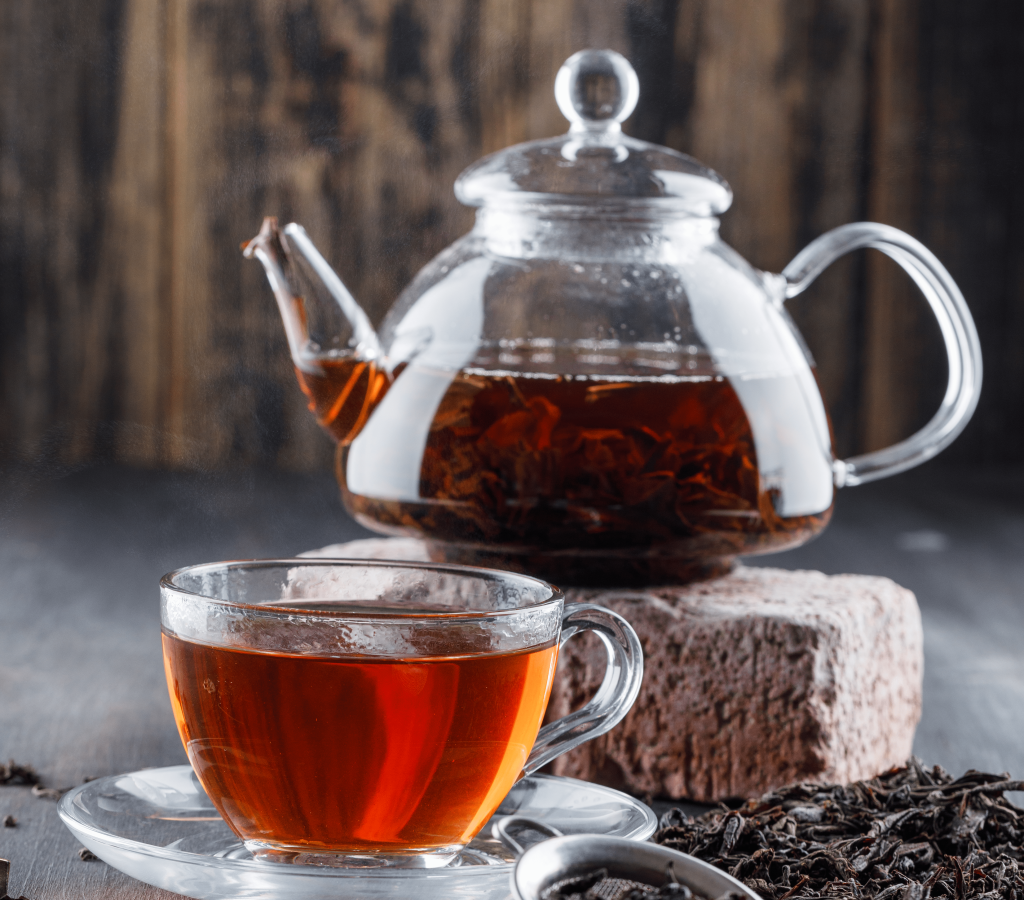 the-noir-dans-une-theiere-et-une-tasse-de-the-sec-vue-laterale-en-brique-sur-une-surface-en-bois-min-min